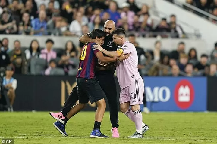 Lionel Messi's security pulls pitch invader around the neck and yanks him away from the Argentine star