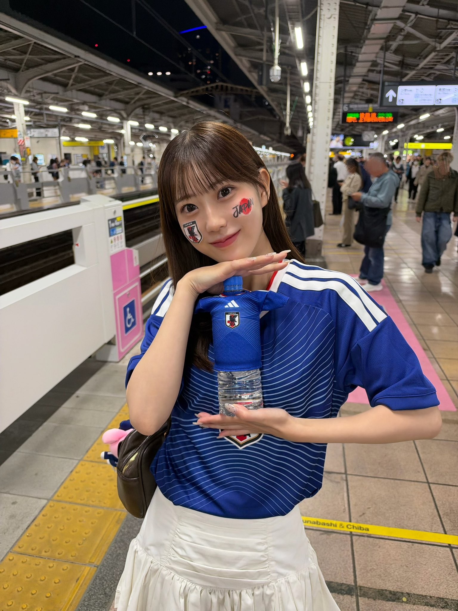 Bahnhof wird zur Fanzone! Studentin Honoka Kumikita trägt Japan-Trikot zur Unterstützung des Teams